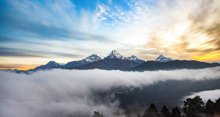 Dramatischer Blick auf wolkenverhangene Berge im Morgengrauen.