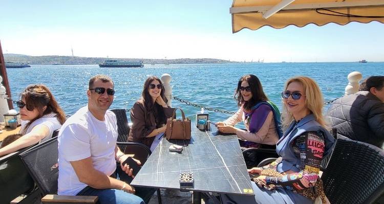 Cena grupal junto al mar con clima soleado.