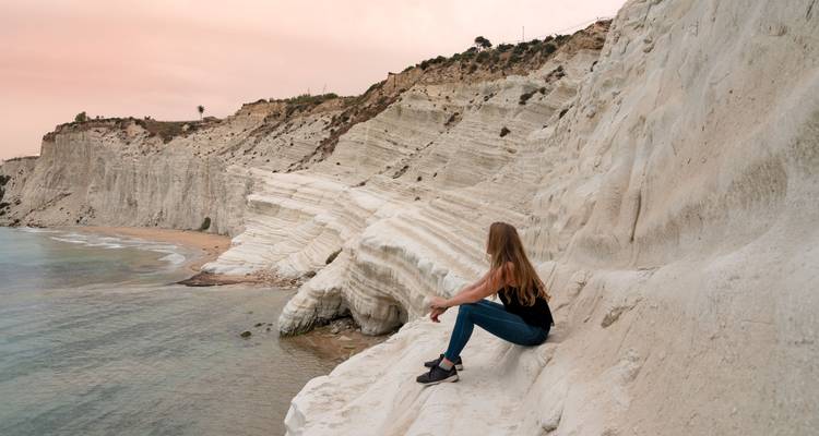 Personne assise sur les bords de falaises blanches crayeuses au bord de la mer.