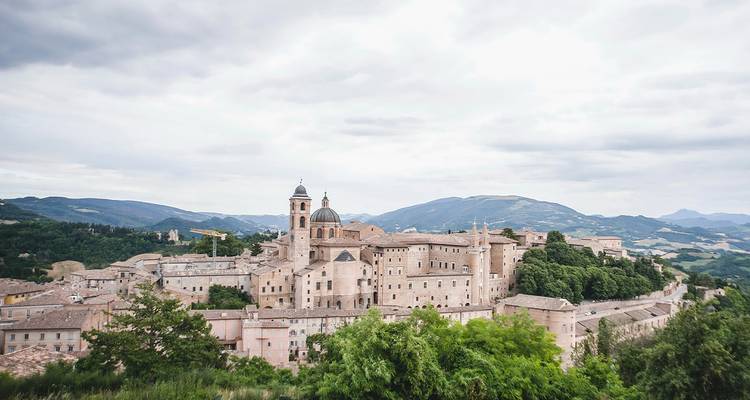 Historische stad met stenen bouwwerken en bergachtige achtergrond.