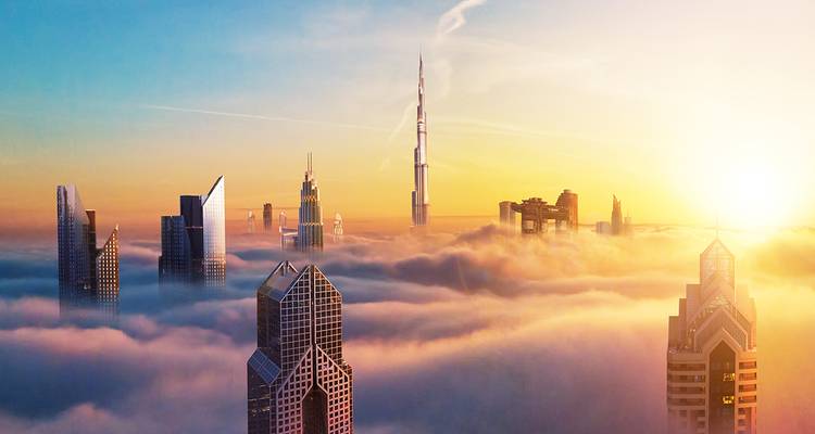 Gratte-ciel émergeant du brouillard avec la Burj Khalifa en arrière-plan.