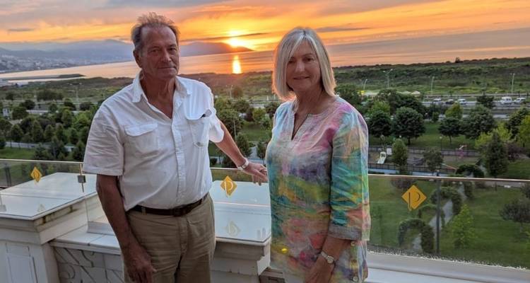 Couple enjoying a sunset view from a terrace.