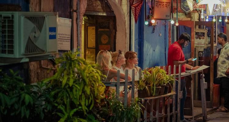People sitting at an outdoor restaurant during the evening.