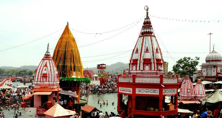 Bunte Tempel an einem Fluss mit besuchenden Menschen.