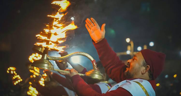 Mann führt ein Feuerritual zur Nachtzeit durch.