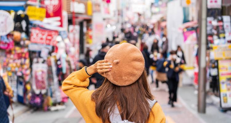 Person, die einen belebten Straßenmarkt mit lebendigen Ständen erkundet.