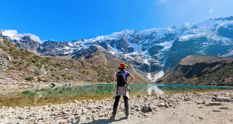 Wandelaar die het uitzicht op een met sneeuw bedekte berg en meer bewondert