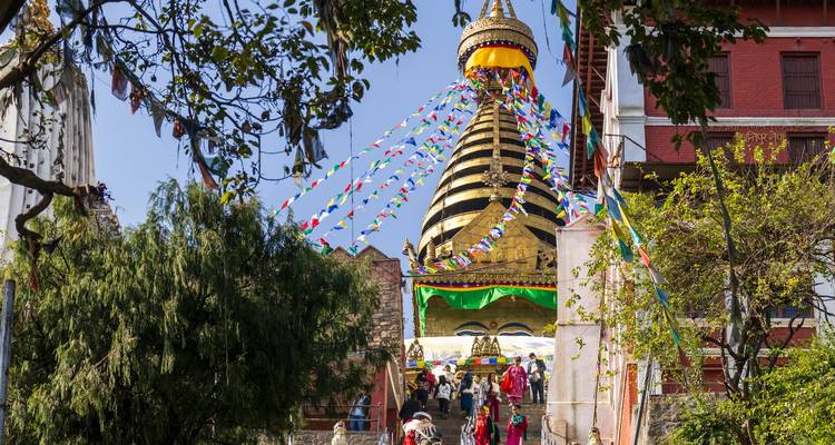 Versierde stoepa met gebedsvlaggen en mensen.