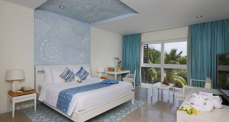 Helles, modernes Hotelzimmer mit großen Fenstern und blauer Dekoration.