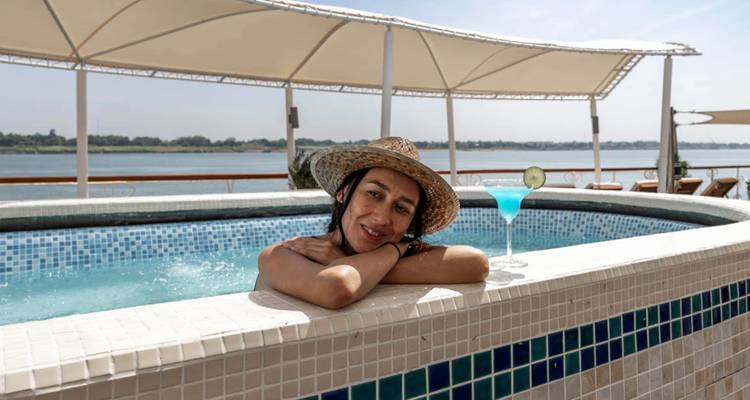 Frau entspannt sich in einem Pool mit einem Cocktail auf einem Kreuzfahrtschiff.