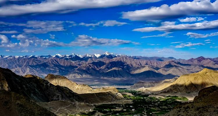 Chaîne de montagnes avec des sommets enneigés et une vallée.