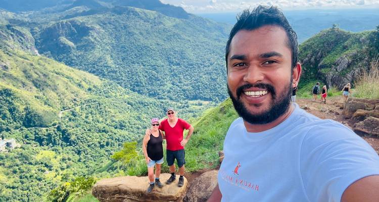 Un grupo posando en una ladera pintoresca con vegetación exuberante.