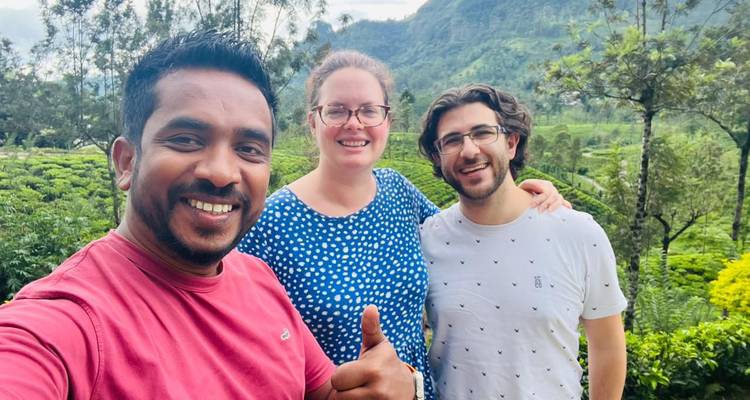 Tres personas posando en un jardín con vegetación alrededor.
