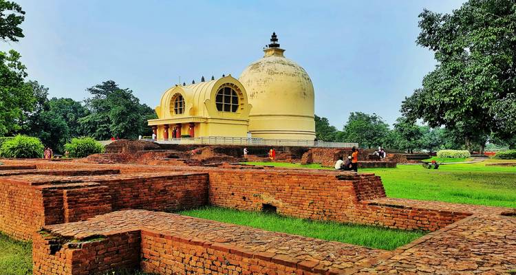 Rundes weißes Mausoleum mit Besuchern auf dem Gelände.