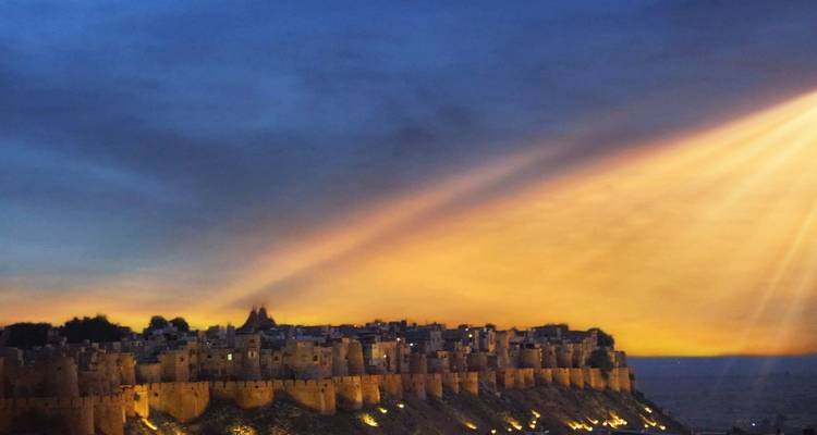 Een verlicht fort onder een dramatische zonsonderganghemel.