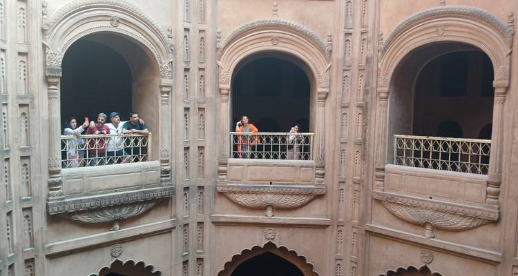 Group of people on balconies inside a historic building.