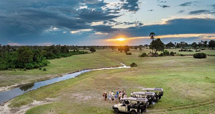Group of people gathered in the savannah during sunset