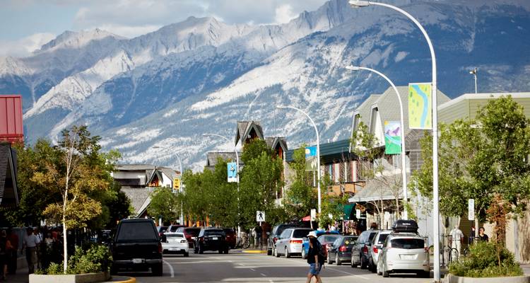 Straßenansicht einer Stadt in den Bergen mit Menschen und Autos.