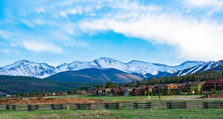 Berg mit schneebedeckten Gipfeln mit Blick auf ein Wohngebiet.