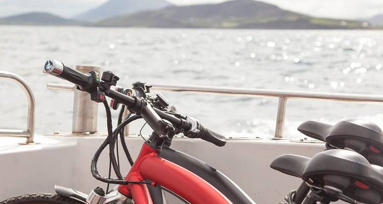 Bicycle on a boat with mountain views in the background.