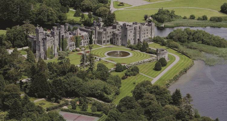 Aerial view of Ashford Castle surrounded by lush greenery.