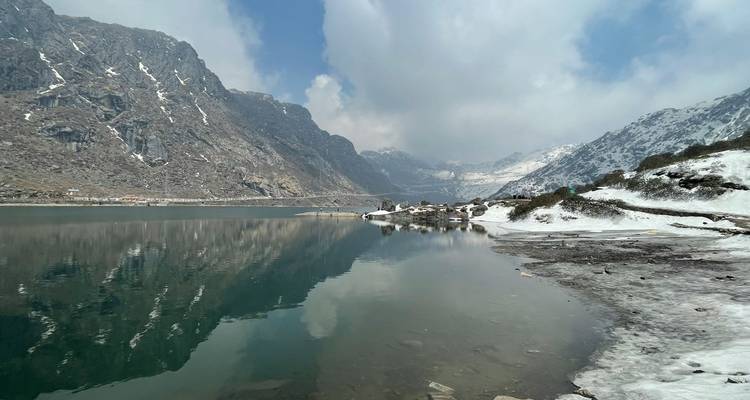 Un lago sereno con reflejos de montañas cubiertas de nieve.