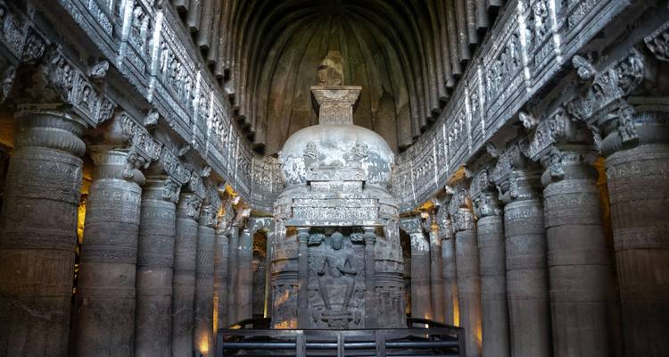 Interieur van een in de rots uitgehakte tempel met religieuze beelden en gravures.