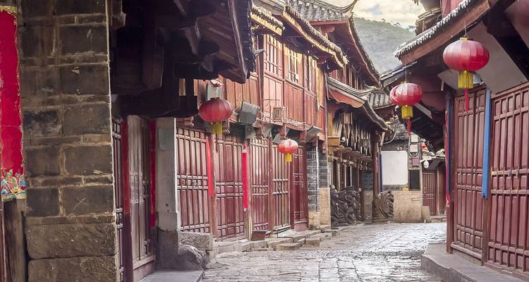 Stil steegje met kinderkopjes in de oude binnenstad van Lijiang, omzoomd met rode lantaarns en houten gevels