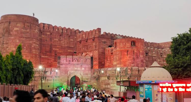 Rode Fort Agra met een drukke menigte in de avond.
