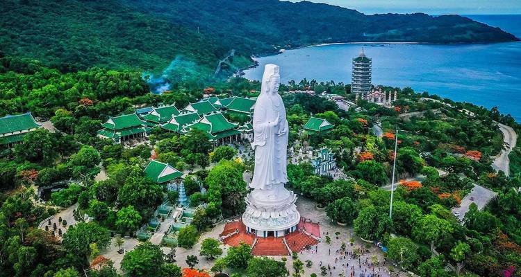 Vue aérienne d'une grande statue entourée de collines verdoyantes.