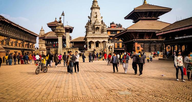 Historischer Platz mit traditioneller Architektur und Menschen, die umhergehen.
