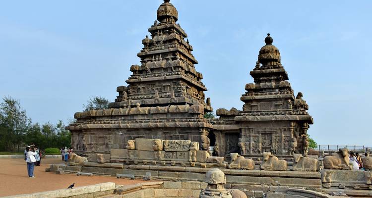 Alter Steintempel mit kunstvollen Schnitzereien und Besuchern.