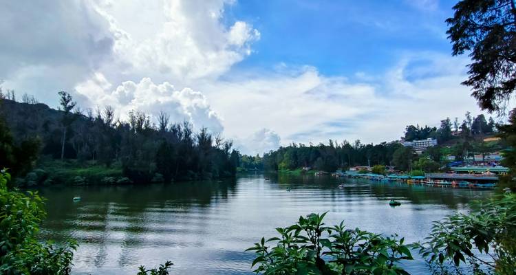 Lac avec collines lointaines et ciel nuageux.