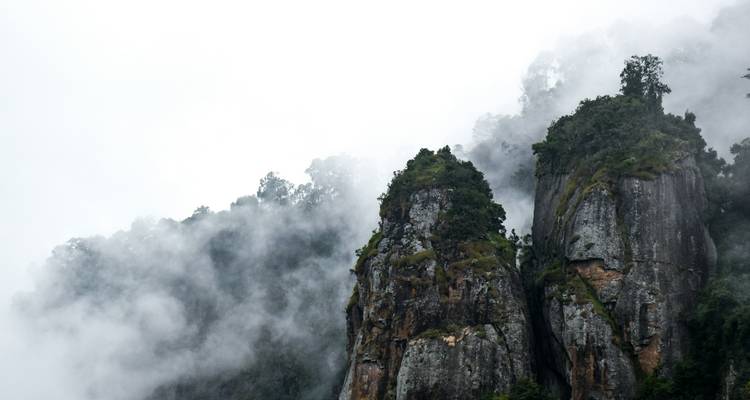 Coteau rocheux au milieu de la brume et des nuages.