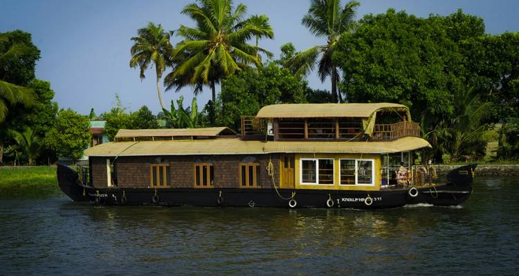 Woonboot op een serene waterweg met weelderige groenvoorziening.