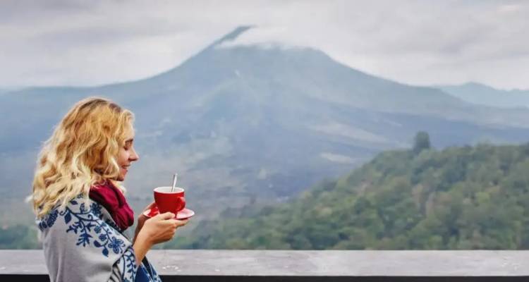 Femme avec une tasse de café ou de thé avec vue sur un paysage montagneux pittoresque.