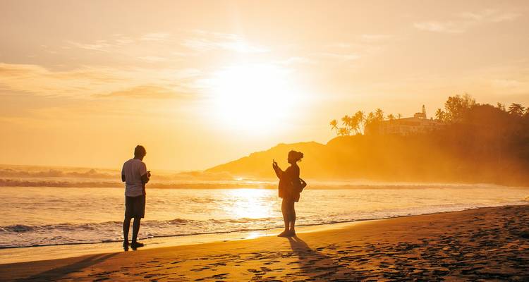 Couple enjoying a sunset on a beach.