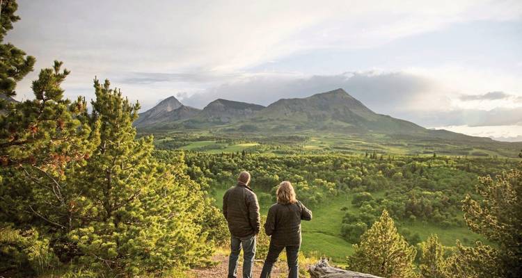 Two people enjoying a view of a mountainous landscape.