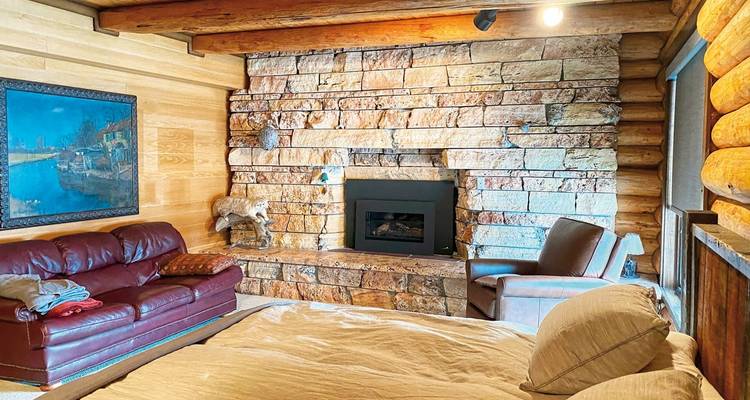 Cozy room with a stone fireplace and rustic decor.