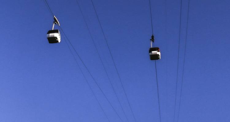 Seilbahnen vor einem klaren blauen Himmel.