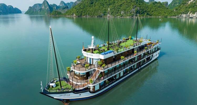 Luxury cruise boat in calm waters surrounded by green hills.