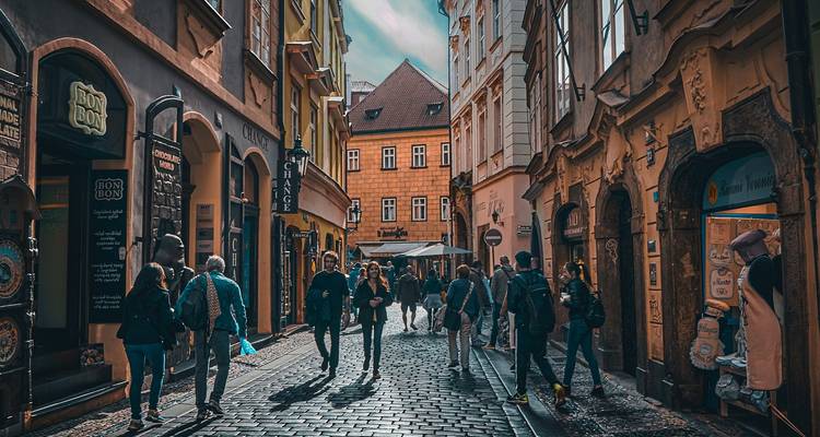 Menschen, die auf einer Kopfsteinpflasterstraße in Prag gehen.