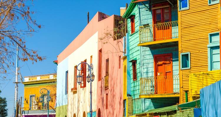 Bâtiments aux couleurs vives dans un quartier sous un ciel bleu dégagé.