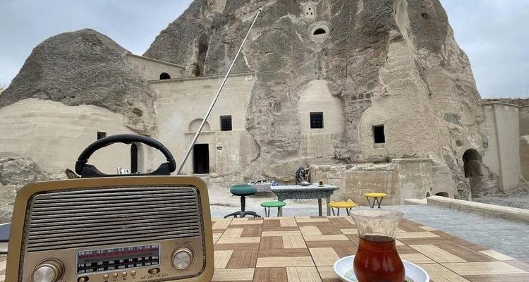 Vintage radio en theeset op een tafel tegen een rotsachtige achtergrond.