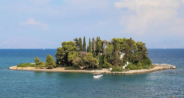Kleine üppig grüne Insel mit klarem blauen Wasser.