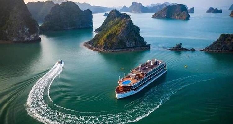 Cruiseschip dat vaart rond kalkstenen karstformaties in een baai.