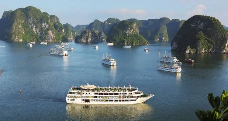 Cruiseschepen die navigeren in een baai met karstformaties.