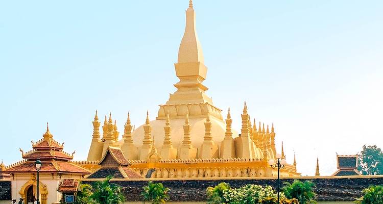 Goldene Stupa mit kunstvoller Architektur vor einem klaren Himmel.