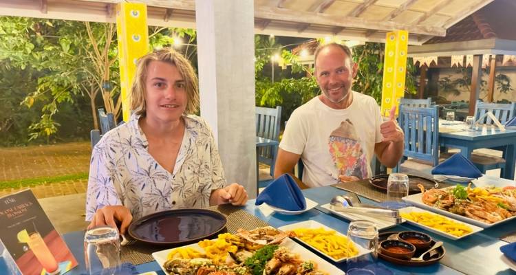 Two people dining with seafood and fries at a restaurant.