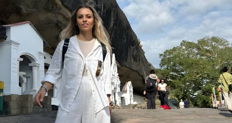 Person standing in front of a white temple complex.
